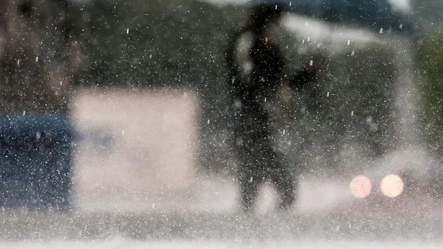 Foto de pessoa andando na chuva com guarda-chuva, ela está desfocada. Foto de pessoa andando na chuva com guarda-chuva, ela está desfocada.