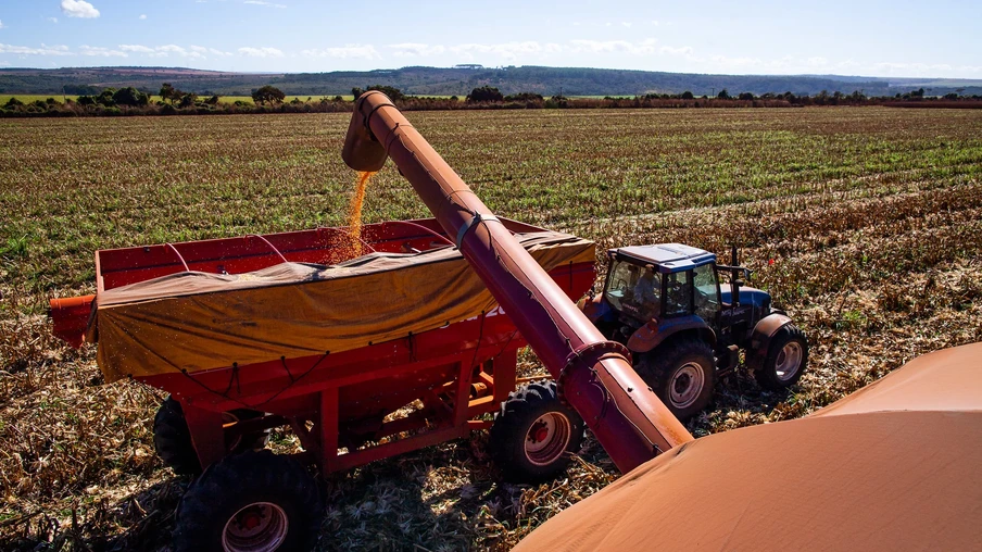 Foto de colheitadeira despejando grãos de milho em carreta. Foto de colheitadeira despejando grãos de milho em carreta.