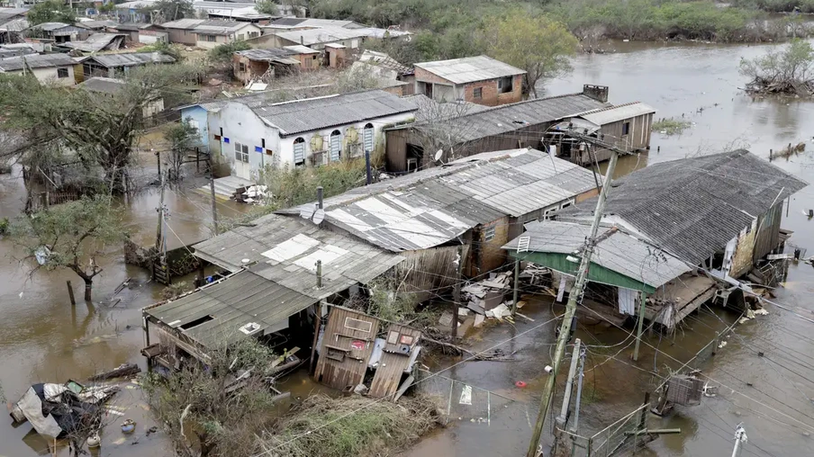 Foto de casas destruídas e rodeadas por água. Foto de casas destruídas e rodeadas por água.