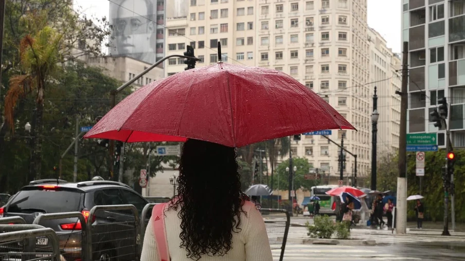 Foto de mulher sob guarda-chuva vermelho em uma rua. Foto de mulher sob guarda-chuva vermelho em uma rua.