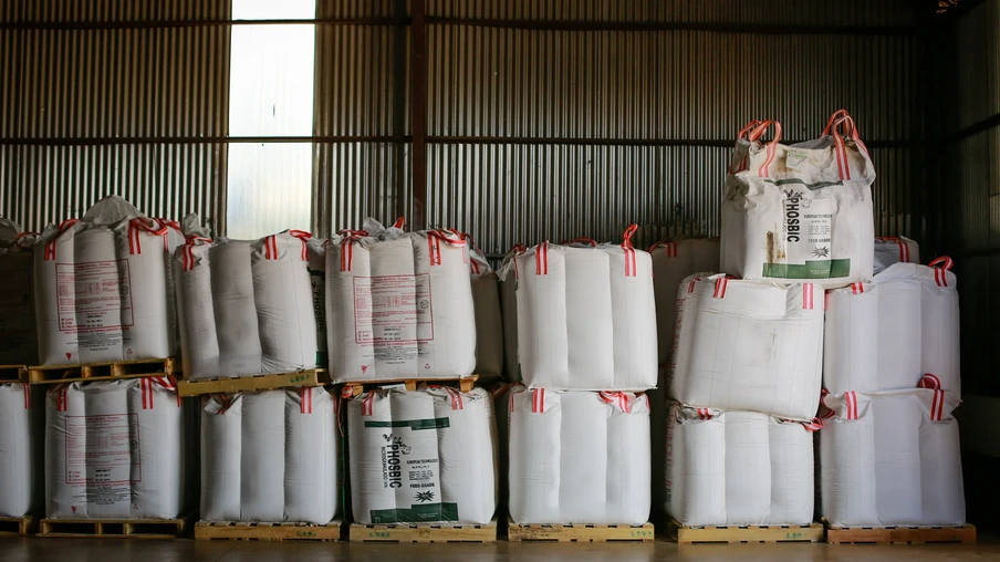 Foto de sacos de fertilizantes empilhados e enfileirados em galpão. Foto de sacos de fertilizantes empilhados e enfileirados em galpão.