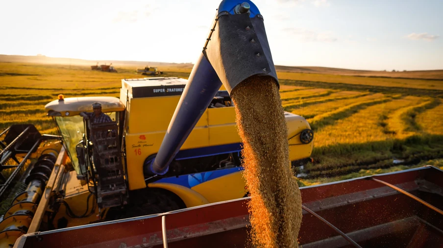 Foto de colheitadeira despejando grãos de arroz em carreta. Foto de colheitadeira despejando grãos de arroz em carreta.