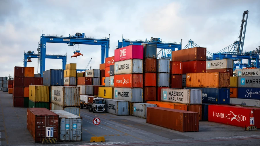 Foto de containers de diferentes cores em porto. Foto de containers de diferentes cores em porto.