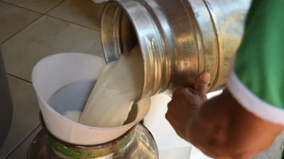 Foto de galão passando leite para outro galão. Foto de galão passando leite para outro galão.