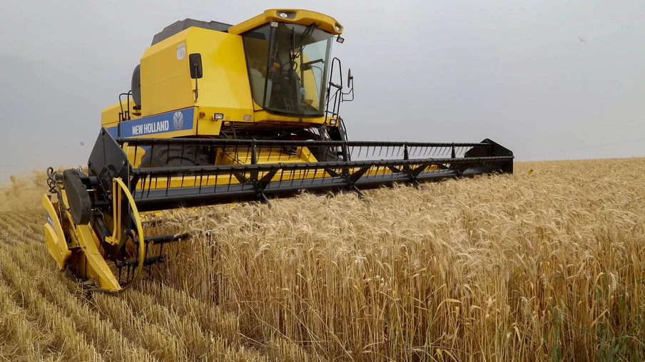 Foto de colheitadeira em lavoura de trigo. Foto de colheitadeira em lavoura de trigo.