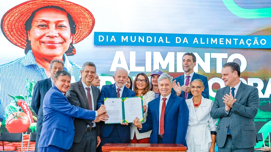 Foto do Presidente da República, Luiz Inácio Lula da Silva cercado por ministros e outras pessoas segurando pasta aberta com decreto. Foto do Presidente da República, Luiz Inácio Lula da Silva cercado por ministros e outras pessoas segurando pasta aberta com decreto.