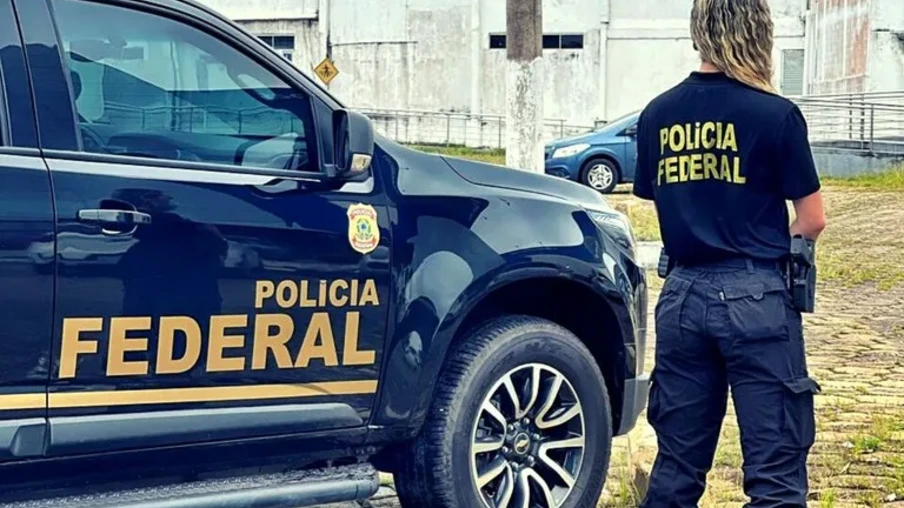 Foto de policial federal de costas ao lado de viatura. Foto de policial federal de costas ao lado de viatura.