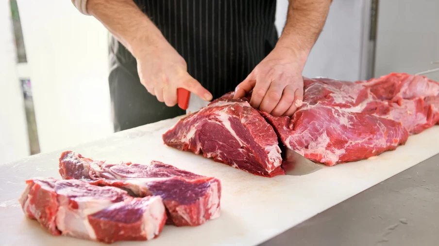 Foto pessoa cortando carne em bancada branca. Foto pessoa cortando carne em bancada branca.