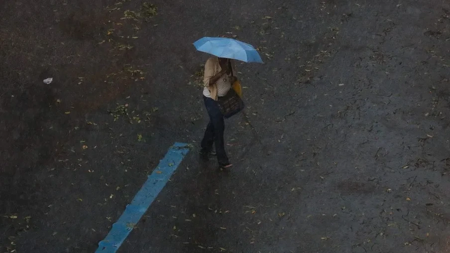 Foto de pessoa, em andando na rua com guarda-chuva enquanto chove. Foto de pessoa, em andando na rua com guarda-chuva enquanto chove.