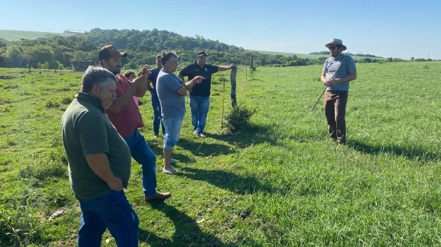 Foto de produtores em pastagem recebendo orientações de homem com chapéu. Foto de produtores em pastagem recebendo orientações de homem com chapéu.