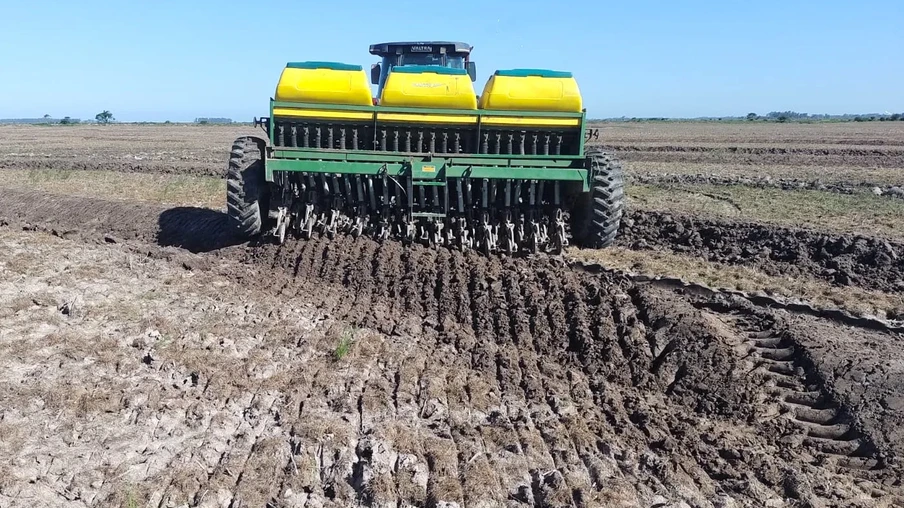 Foto de máquina realizando a semeadura do arroz. Foto de máquina realizando a semeadura do arroz.