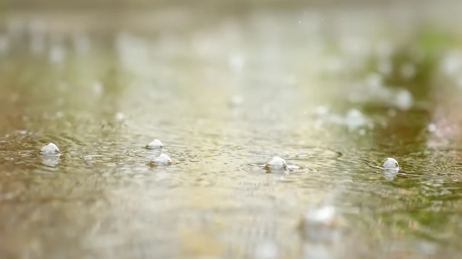 Foto de gotas de água caindo em poça. Foto de gotas de água caindo em poça.