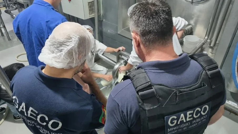 Foto de policiais da Geaco e funcionários de indústria de leite ao redor de tonel. Foto de policiais da Geaco e funcionários de indústria de leite ao redor de tonel.