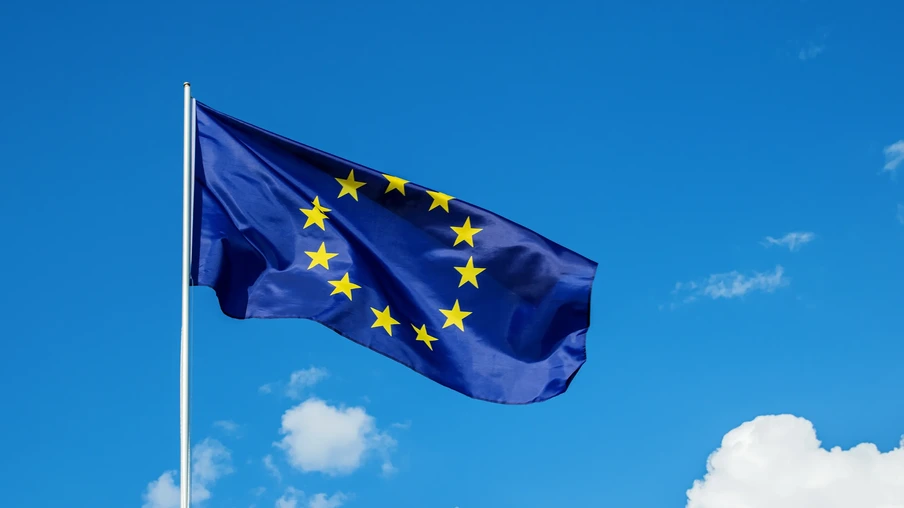 Foto de bandeira da União Europeia tremulando em céu azul. Foto de bandeira da União Europeia tremulando em céu azul.