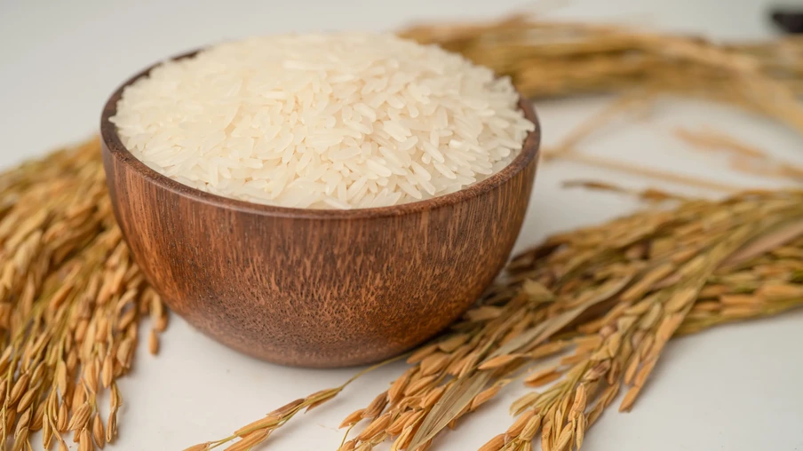 Arroz branco jasmim em tigela de madeira com grãos dourados de fazenda agrícola. Arroz branco jasmim em tigela de madeira com grãos dourados de fazenda agrícola.