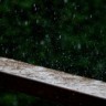 Foto de gotas de chuva caindo sobre madeira.