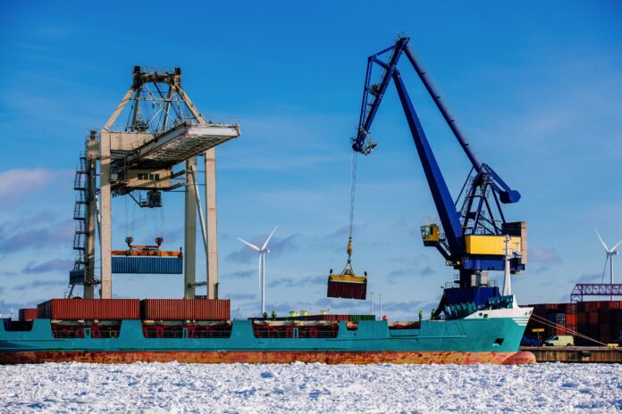 A foto mostra um porto industrial com contentores, carregamento de embarcações no porto da Finlândia